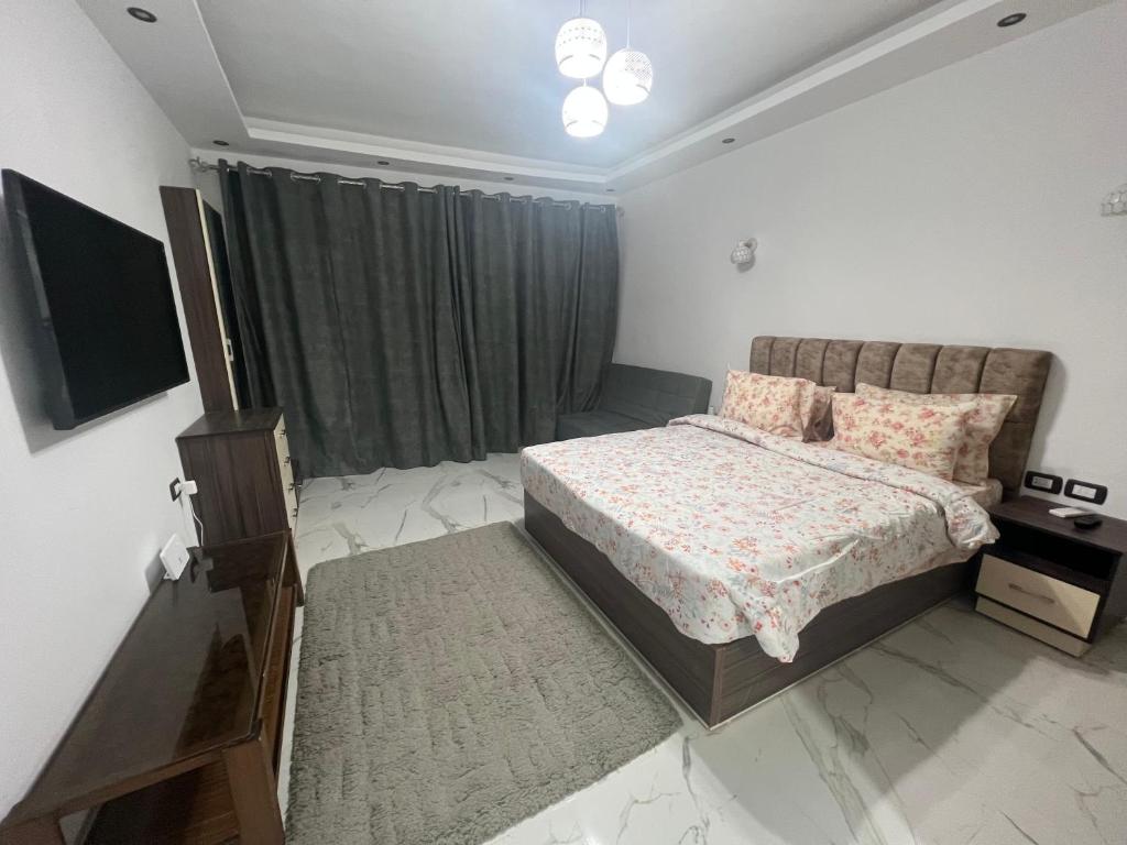 ein Schlafzimmer mit einem Bett und einem TV in der Unterkunft Luxury Apartment Panorama Naama Heights Resort in Sharm El Sheikh