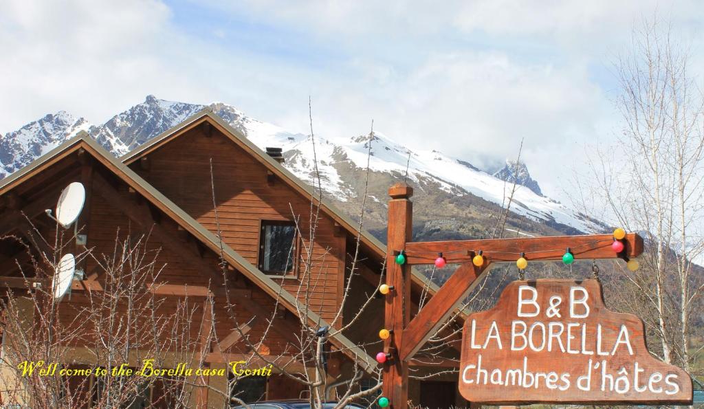 a log cabin with a christmas sign in front of it at B&B La Borella Casa Conti in Vallouise