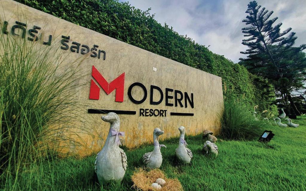 a group of ducks standing in front of a sign at Modern Resort in Ban Khlong Khachen