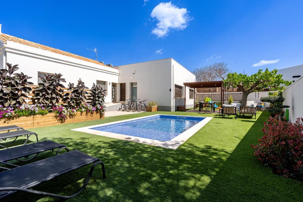 a backyard with a swimming pool and a house at Casa Turón in Deltebre