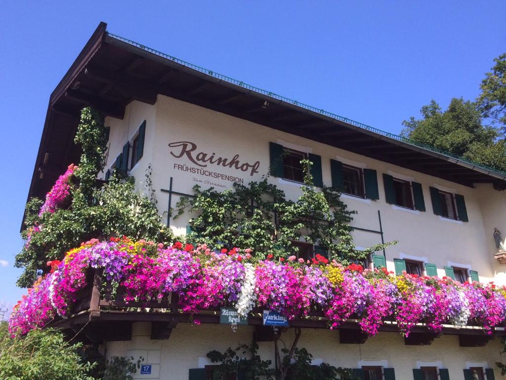 un edificio con flores a un lado. en Pension Rainhof, en Kitzbühel