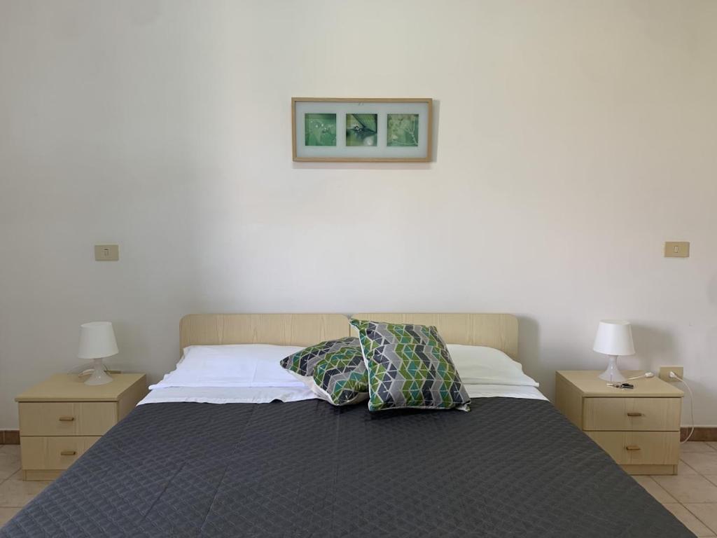 Prignano CilentoにあるGreen House Oasi Fiume Alentoのベッドルーム1室(ナイトスタンド2つ、ランプ2つ付)