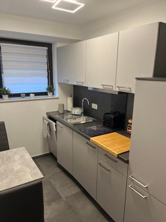a kitchen with white cabinets and a sink at Ferienwohnung Emilia in Cologne