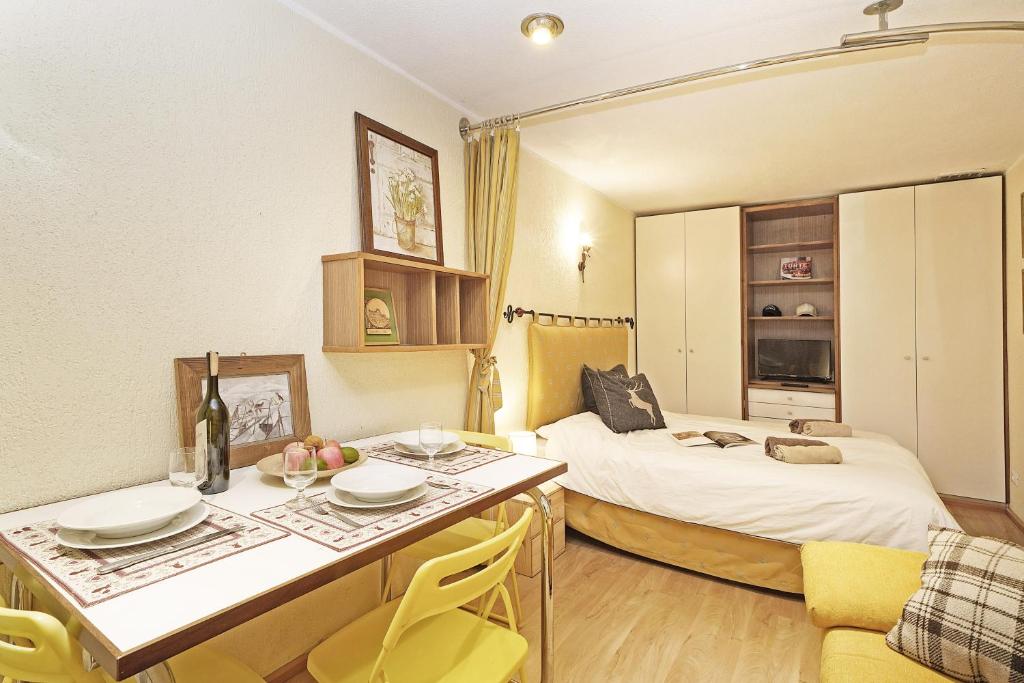 Pokój z 2 łóżkami, stołem i krzesłami w obiekcie iFlat Apartment Madonna di Campiglio Adamello 2 w Madonna di Campiglio