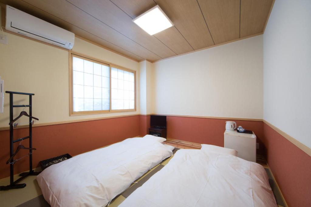 Postel nebo postele na pokoji v ubytování Ebisu Ryokan