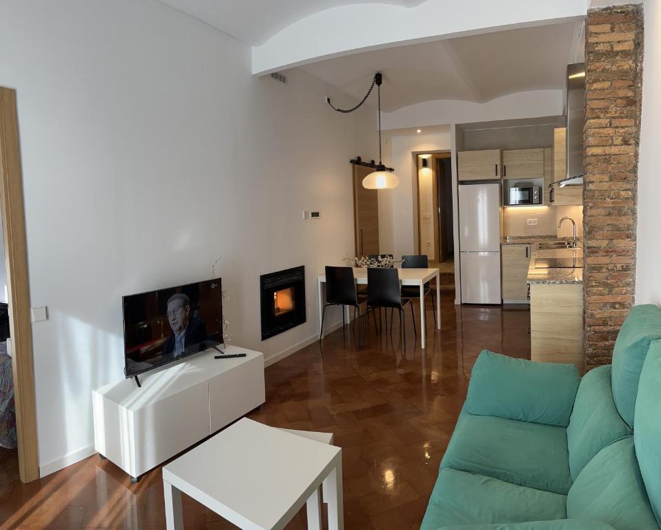 a living room with a couch and a tv in it at Cal Lleuger in Guardiola de Berguedà