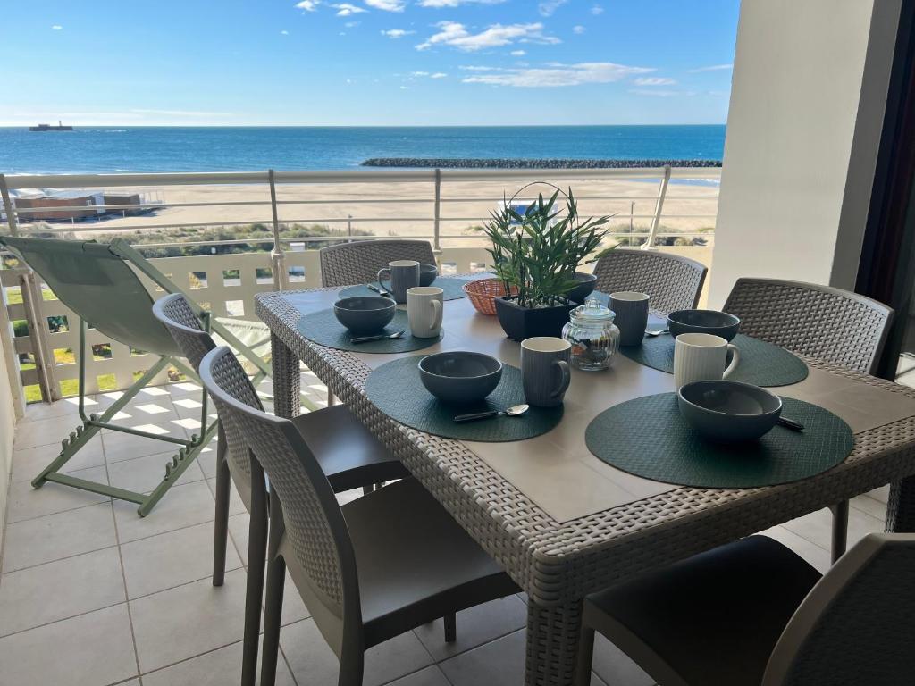 une table sur un balcon avec vue sur la plage dans l'établissement En front de Mer, Magnifique Appartement 6 pers., au Cap d'Agde