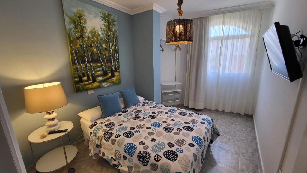 een slaapkamer met een bed en een schilderij aan de muur bij Vintage & Deluxe Apartments in Puerto del Rosario