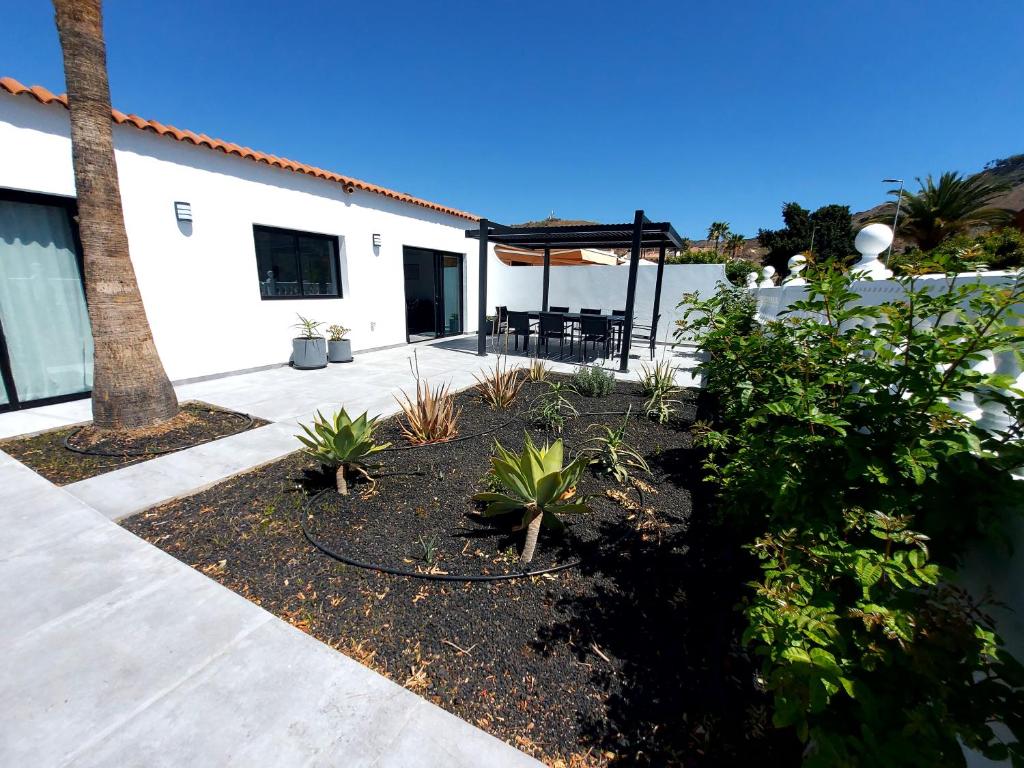 a backyard with a patio with a table and chairs at Villa Playa Tauro - Luxury bungalow with pool in Mogán