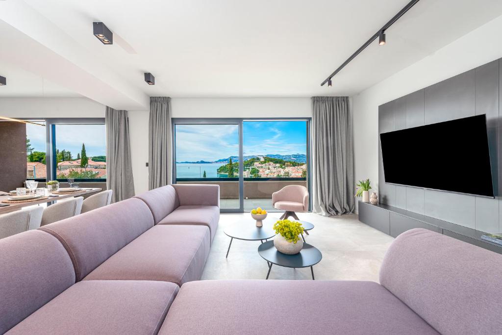 "Villa AnMari" The Cavtat View Residence في كافتات: غرفة معيشة مع أثاث أرجواني وتلفزيون بشاشة مسطحة