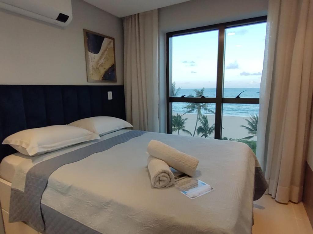 a bedroom with a bed with a view of the ocean at Rio Park Ave, Sea View One - By TRH Invest in Recife