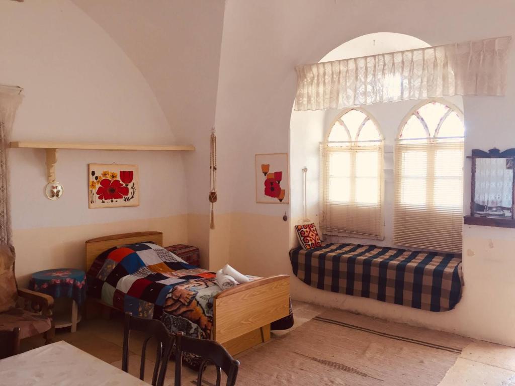 1 dormitorio con 2 camas y ventana en Traditional House with Amazing Veranda en Bethlehem