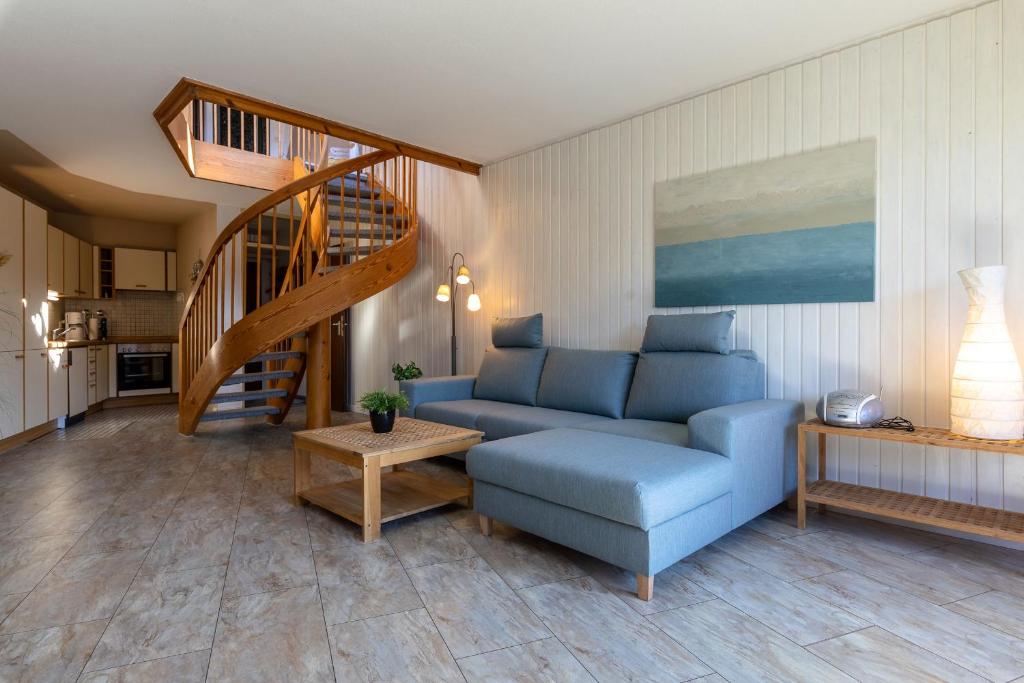 - un salon avec un canapé bleu et un escalier dans l'établissement Ferienwohnpark Immenstaad am Bodensee Maisonette-Wohnung 55 26, à Immenstaad am Bodensee