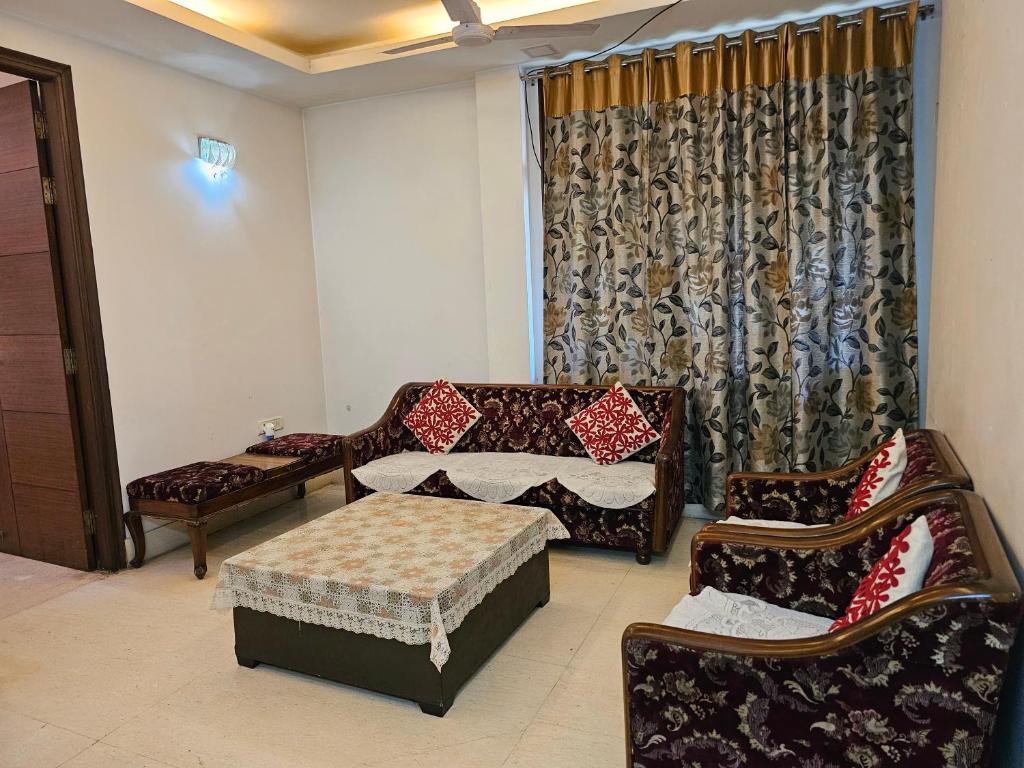 a living room with two chairs and a couch and a table at Spacious 2bhk apartment! in New Delhi