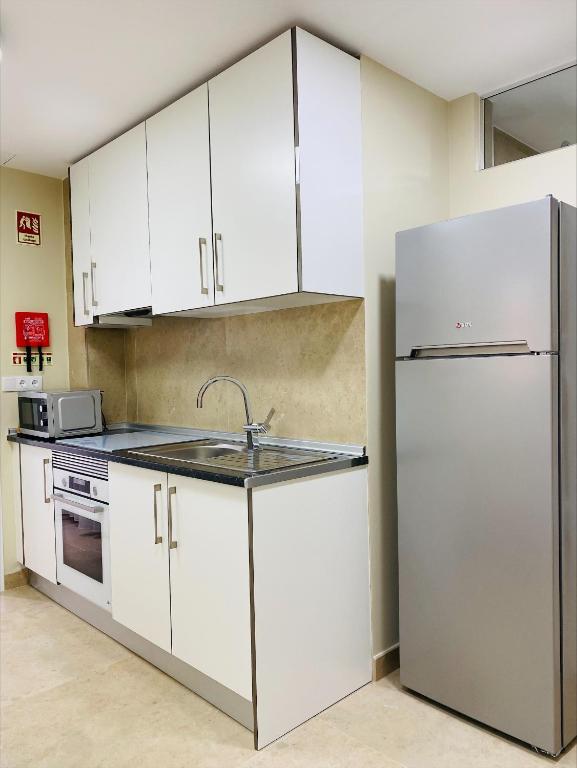 a kitchen with white cabinets and a refrigerator at Lagos Atlantic Hotel in Lagos