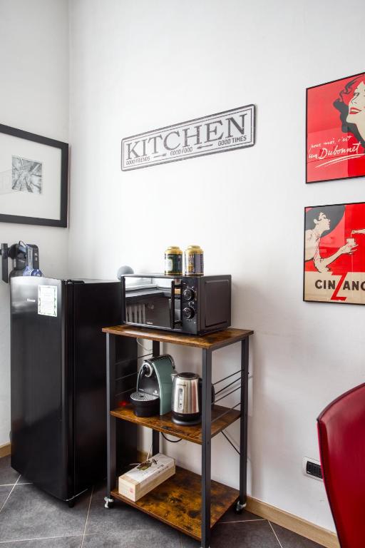 a kitchen with a microwave and a black refrigerator at C Studio - Design Bilo Suite -M3- 8 min dal Duomo in Milan