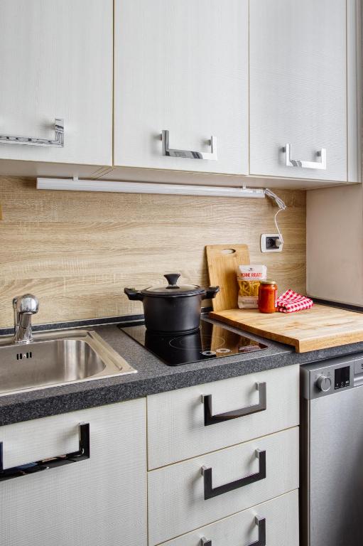 a kitchen with white cabinets and a pot on the stove at C Studio - Design Bilo Suite -M3- 8 min dal Duomo in Milan