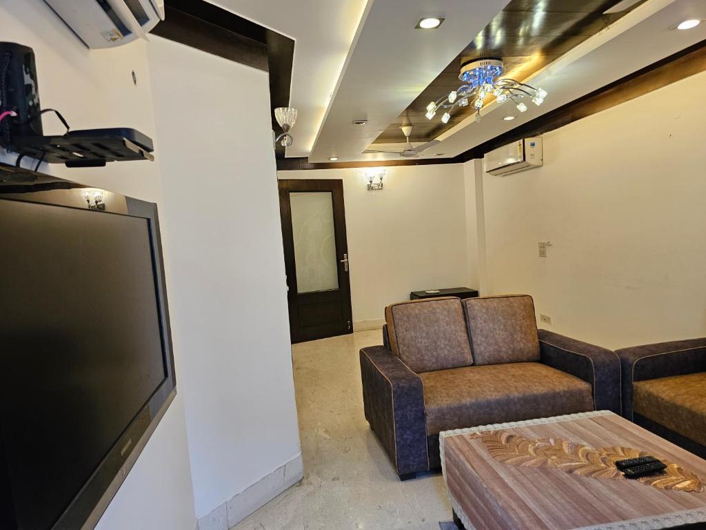 ein Wohnzimmer mit einem Sofa und einem TV in der Unterkunft Palatial 3bhk apartment!Greater kailash 1 in Neu-Delhi