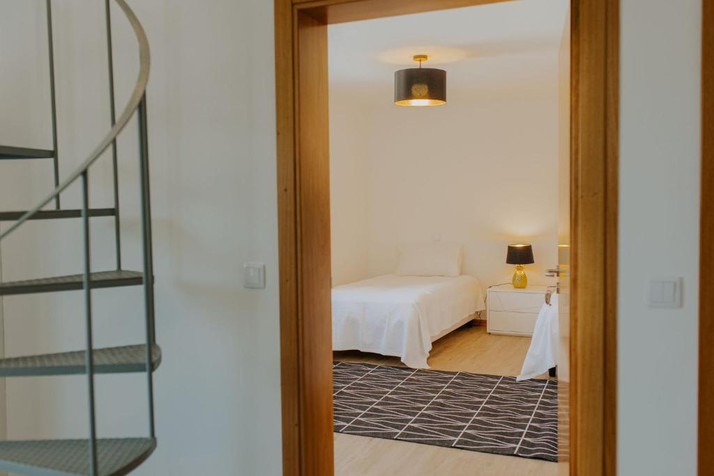 a door leading to a bedroom with a bed at The Passion Fruit House in São Vicente