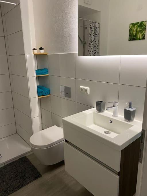 a white bathroom with a sink and a toilet at Unterkunft Waigolshausen in Waigolshausen