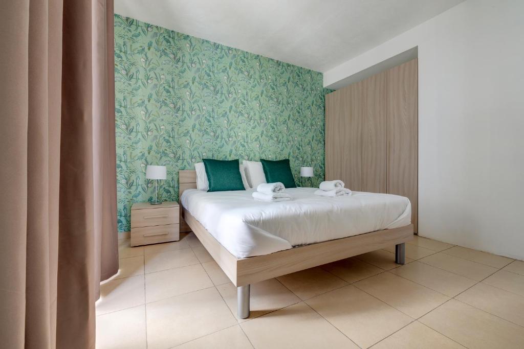 a bedroom with a bed with blue and green walls at Sliema Tigne Suites in Sliema