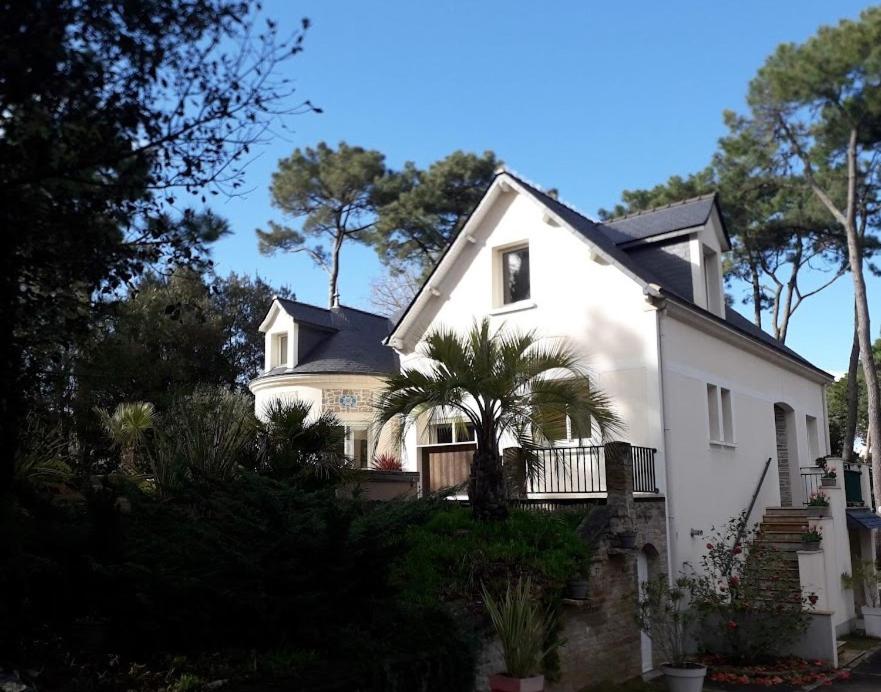 a white house with a palm tree in front of it at Belle de Dune in La Baule