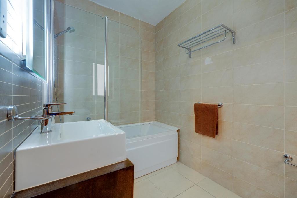 a bathroom with a white sink and a shower at Sliema Tigne Suites in Sliema