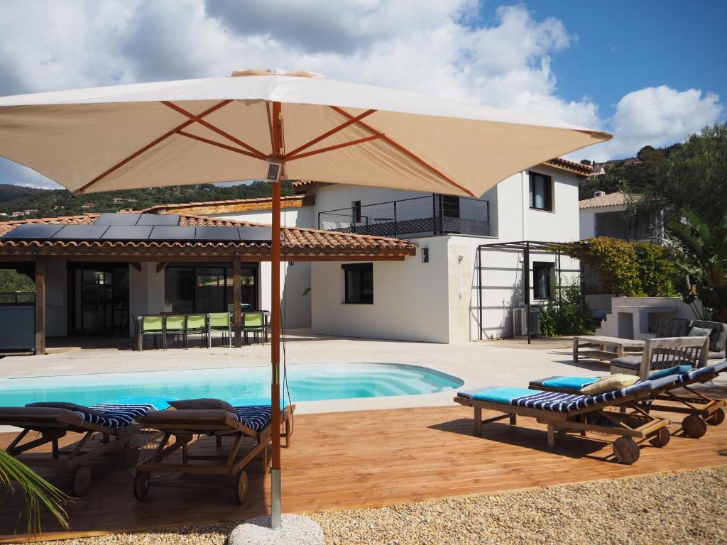 une terrasse avec un parasol, des chaises et une piscine dans l'établissement RÊVE DE MER, à Cavalaire-sur-Mer