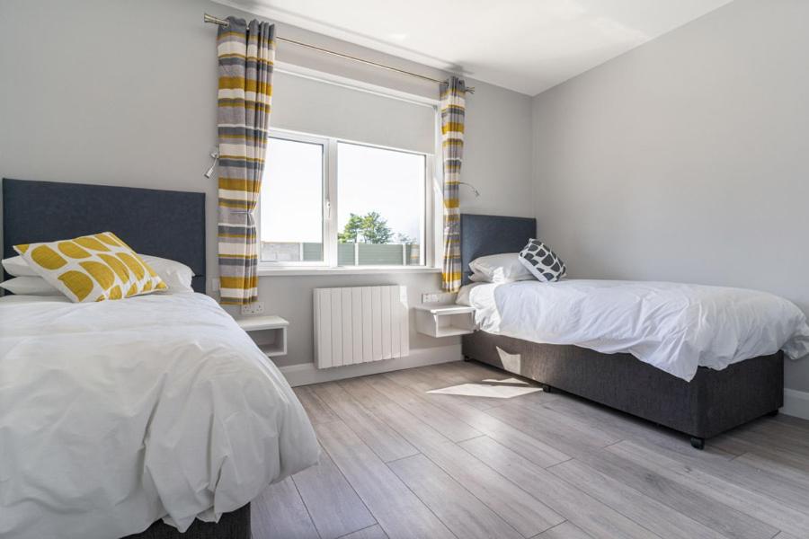 a bedroom with two beds and a window at Sand Dunes Room 3 in Waterford