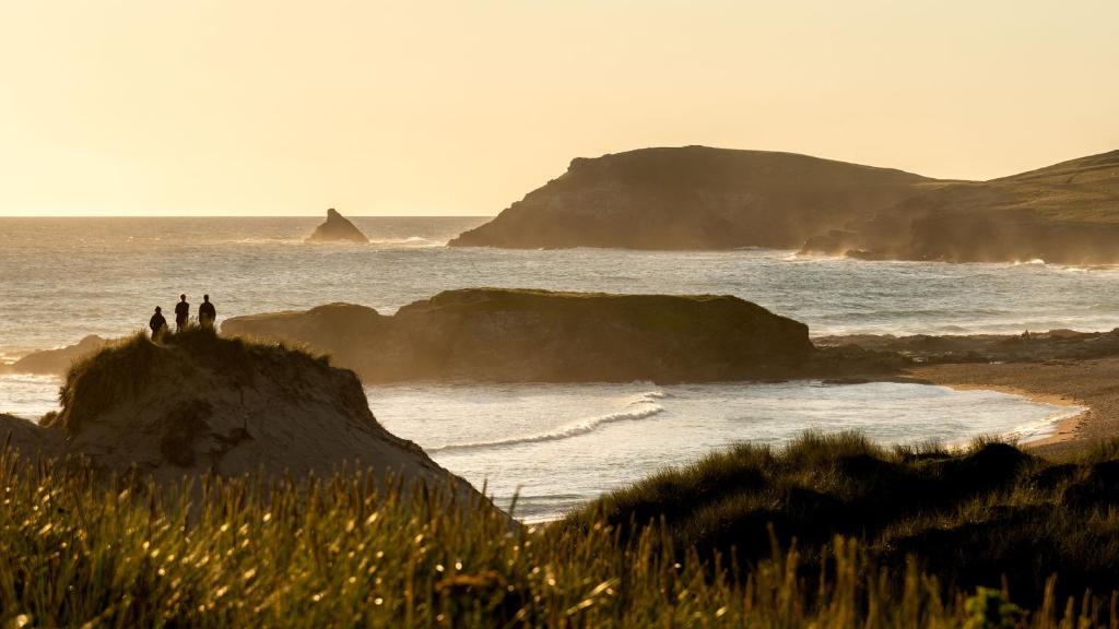 a group of people standing on a rock near the ocean at Trevose Golf and Country Club in Padstow
