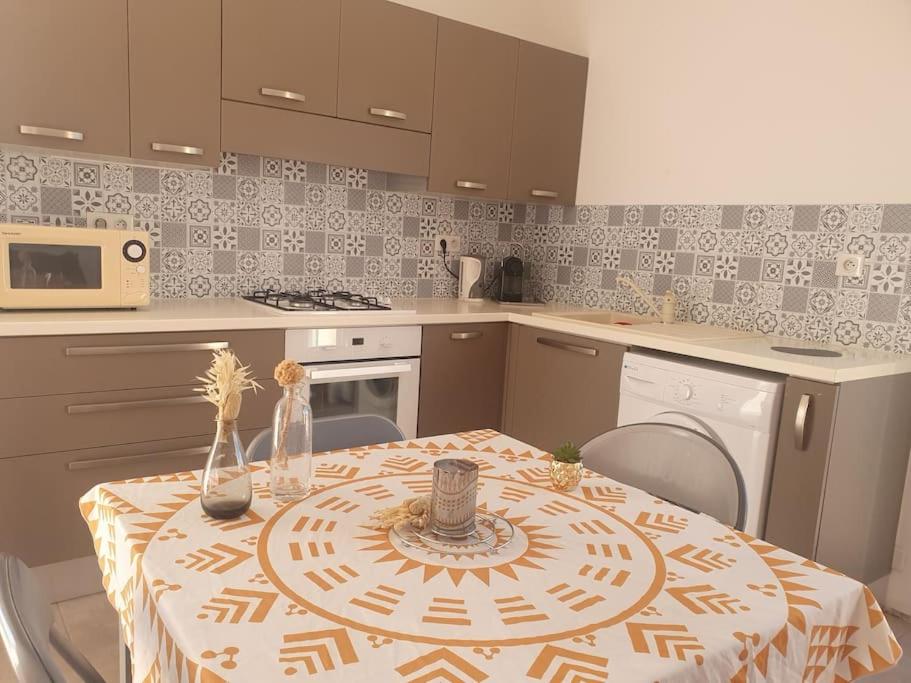 une cuisine avec une table recouverte d'une nappe dans l'établissement Studio mitoyen à la campagne vue sur la mer, à Cargèse