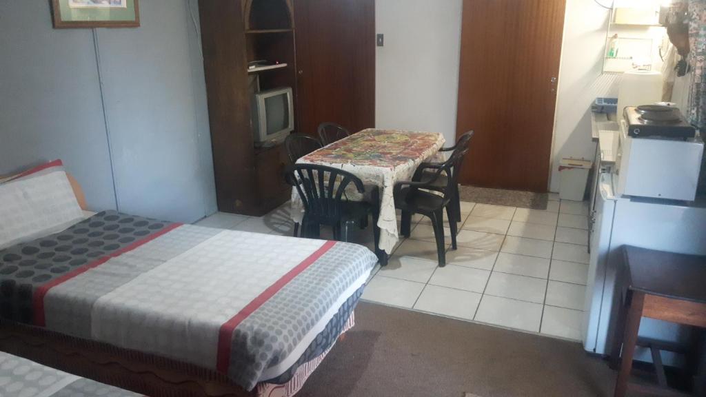 Midway Accommodation في سد غاريب: غرفة مع طاولة وكراسي ومطبخ