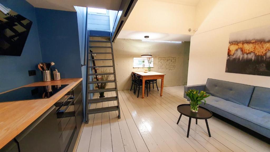 een woonkamer met een blauwe bank en een tafel bij De Fluessen Loft in Elahuizen