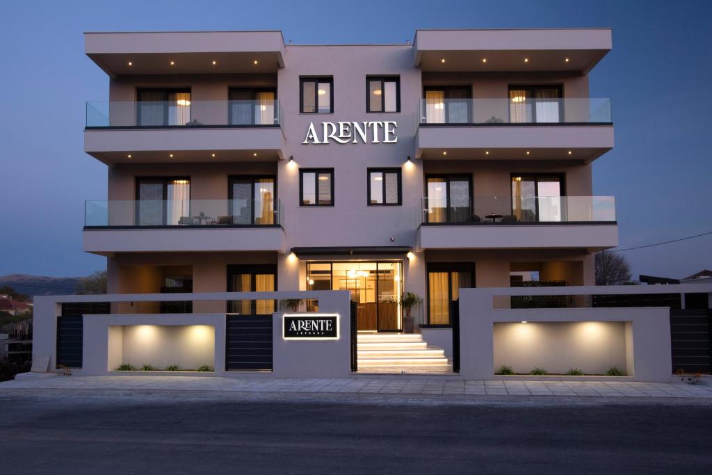 a large white building with a sign in front of it at Arente Apartments in Lefkada Town