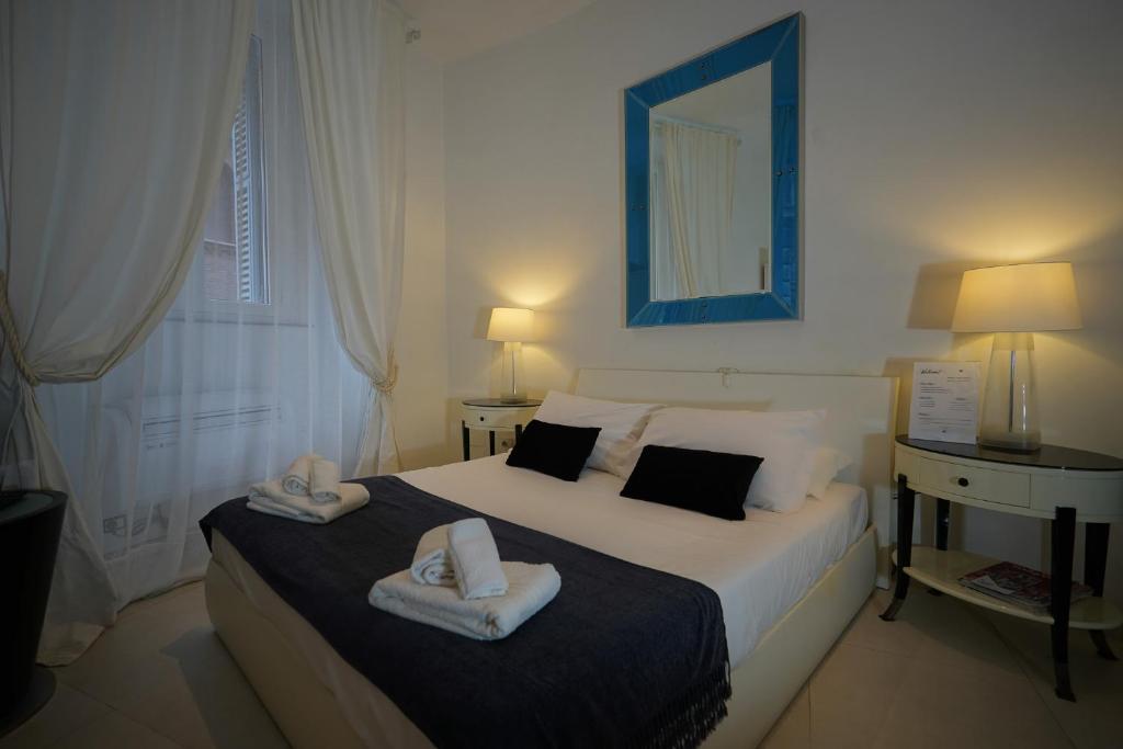 ローマにあるAureliana Apartmentsのベッドルーム1室(ベッド1台、タオル2枚付)