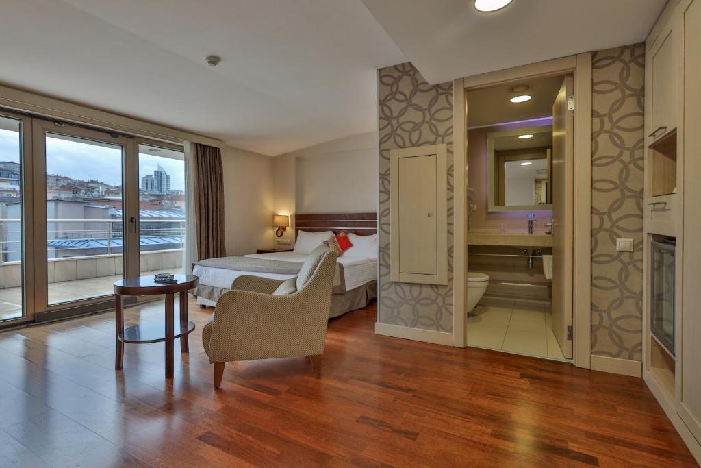 a hotel room with a bed and a desk and a bathroom at Niza Park Hotel in Ankara