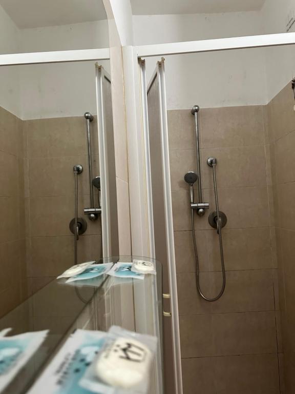 een badkamer met een douche, een wastafel en een spiegel bij Hotel Mercurio in Milaan