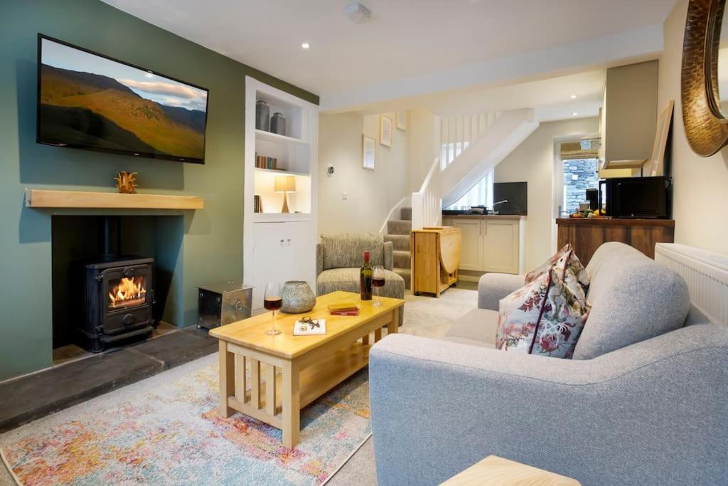 a living room with a couch and a fireplace at Garn Yam Cottage in Ambleside