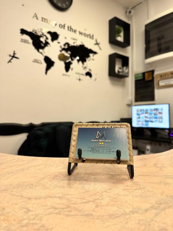 a sign sitting on top of a table at Hotel Mercurio in Milan