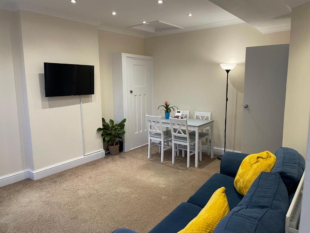 a living room with a blue couch and a table at Super Convenient 2 Double Bed apartment for Central London - 30 seconds walk to platform train station and 19 mins to London Waterloo in London