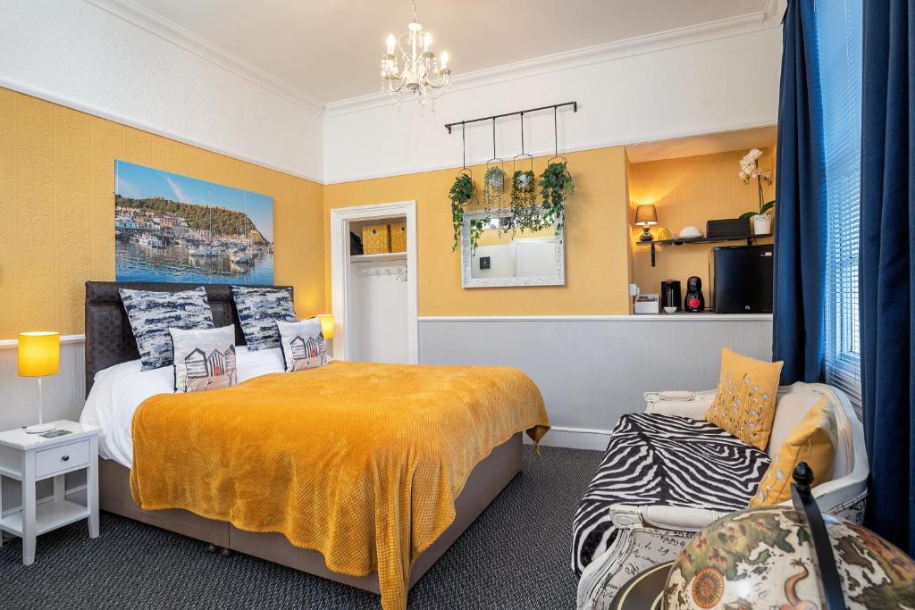 a bedroom with yellow walls and a bed and a chair at Glenholme Guest House - Room Only in Scarborough