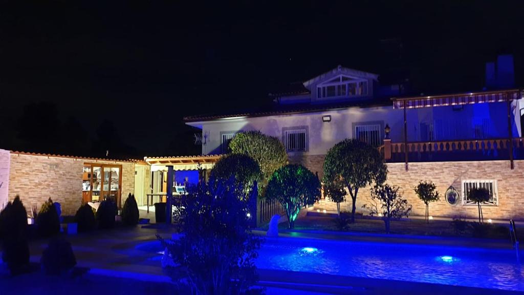 uma grande casa branca à noite com luzes azuis em Hacienda Cruz em Toledo