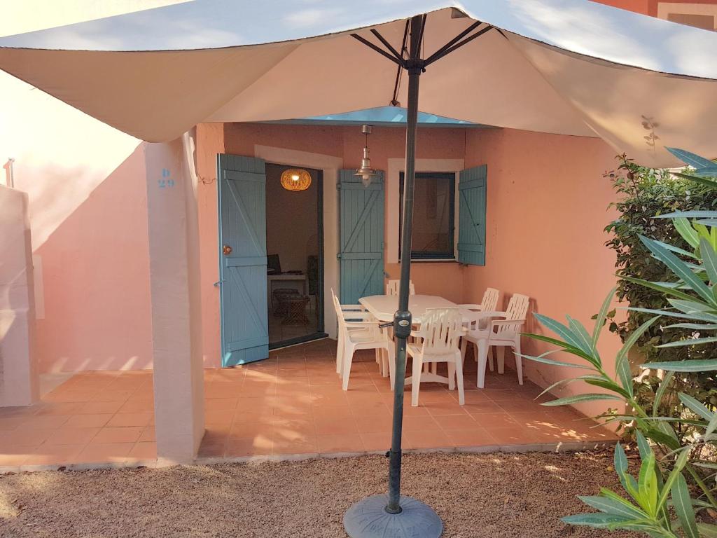 een witte parasol op een patio met een tafel en stoelen bij ST CYPRIEN D29 -4/5 pers- à 250m de la plage de sable Saint Cyprien in Lecci