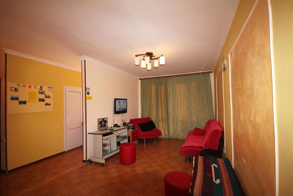 a living room with red chairs and a desk at Center Hostel and Tours in Yerevan