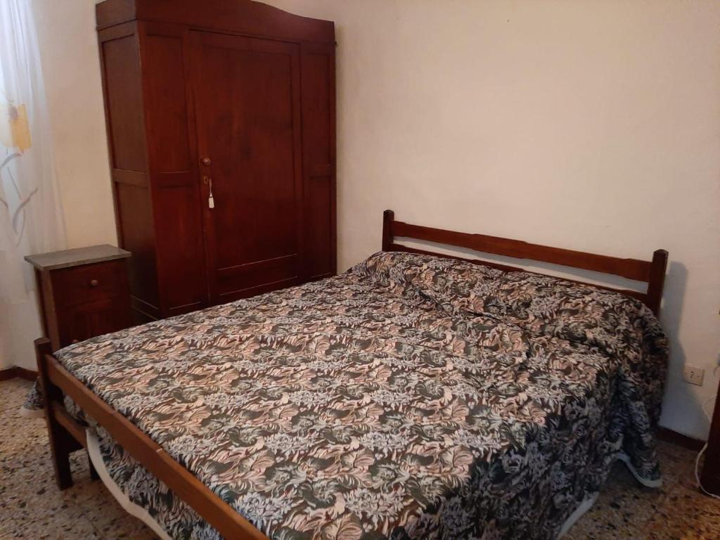 - une chambre avec un lit et une commode en bois dans l'établissement Zara House, à CastellʼAzzara