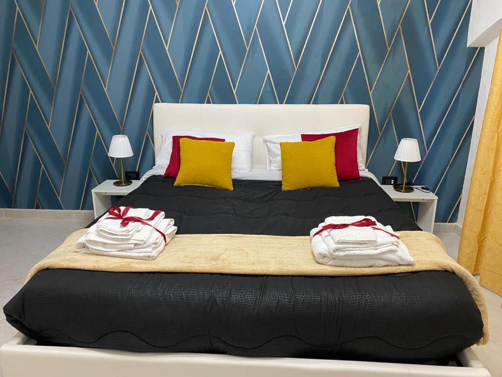 a bedroom with a large bed with red and yellow pillows at Pontecorvo Naples Apartament in Naples