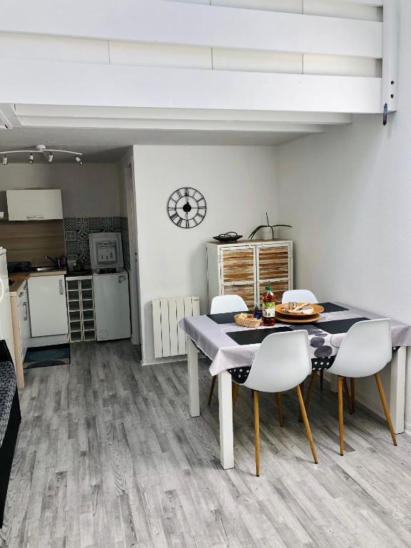 une cuisine et une salle à manger avec une table et des chaises dans l'établissement Appartement duplex lumineux idéalement situé, à Arès
