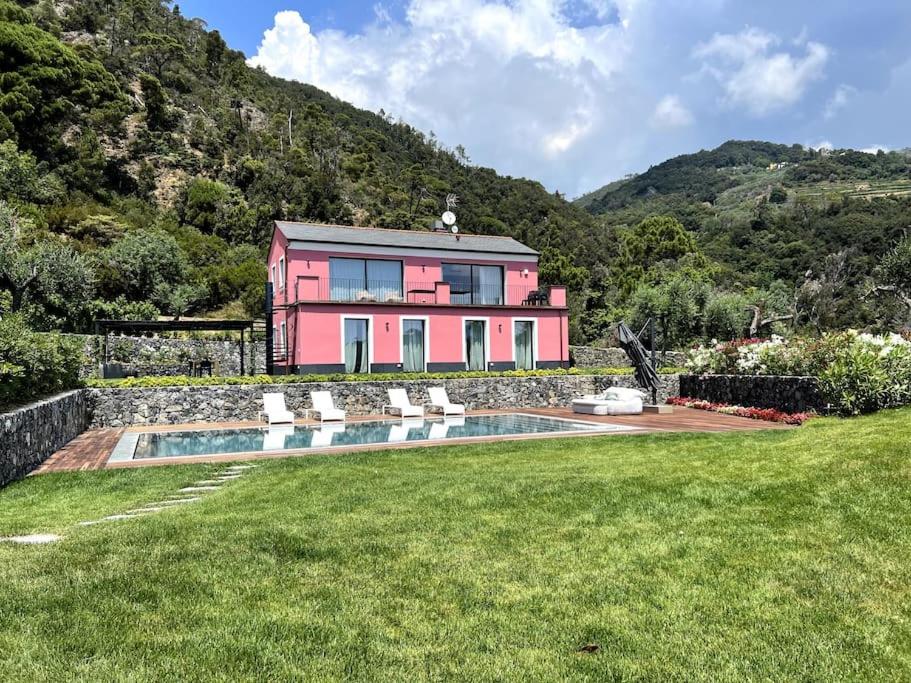 a pink house with a swimming pool in a yard at Villa al Cio, Bonassola in Bonassola