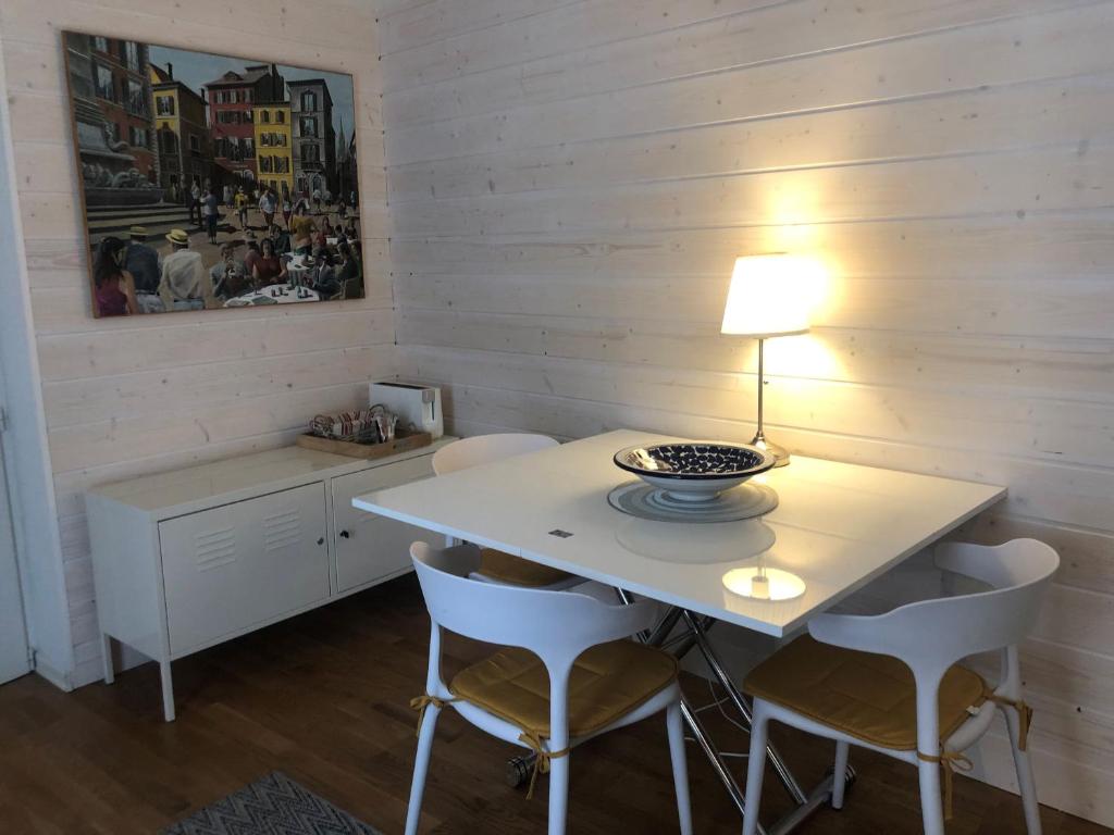 einen weißen Tisch mit Stühlen und eine Lampe drauf in der Unterkunft Gite Jasmin in Herrlisheim-près-Colmar
