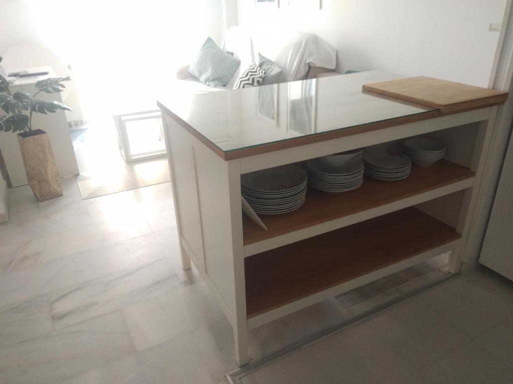 a white counter with plates on a shelf at Zaharaiso luz in Zahara de los Atunes